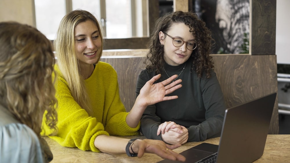 three web developers at a table having a discussion